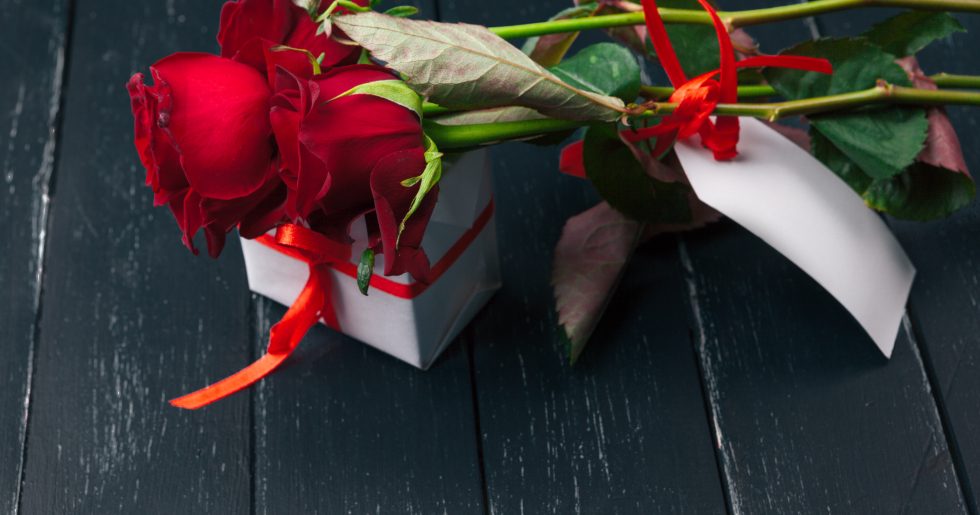 St. Valentines Day. Red roses and gift box on wooden table